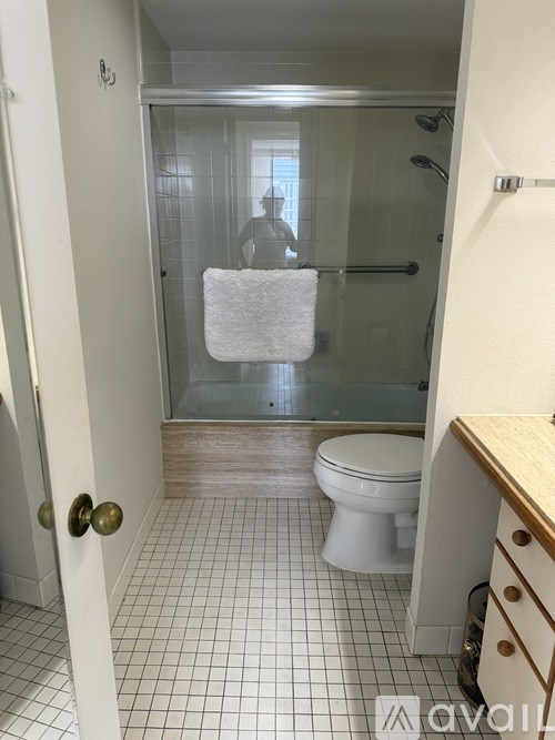 A bathroom with a toilet, sink, and shower.