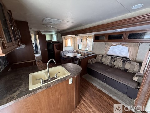 A kitchen area with a sink and a couch in the background.