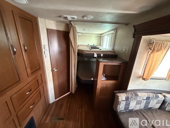 A bedroom with a bed, a desk, and a wardrobe.