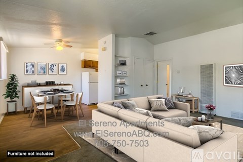 A well-lit living room with a dining area and a kitchen in the background.