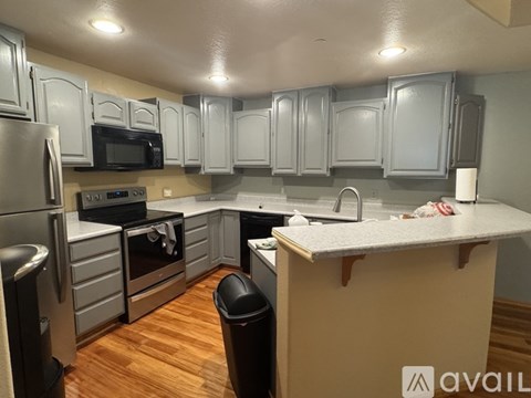 A kitchen with wooden floors and a white counter top.