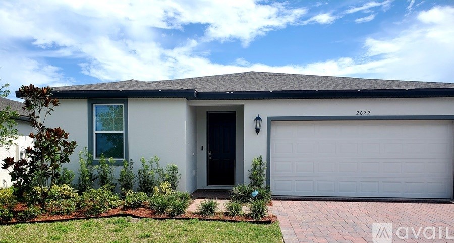 A house with a grey garage door and a black door is for sale.