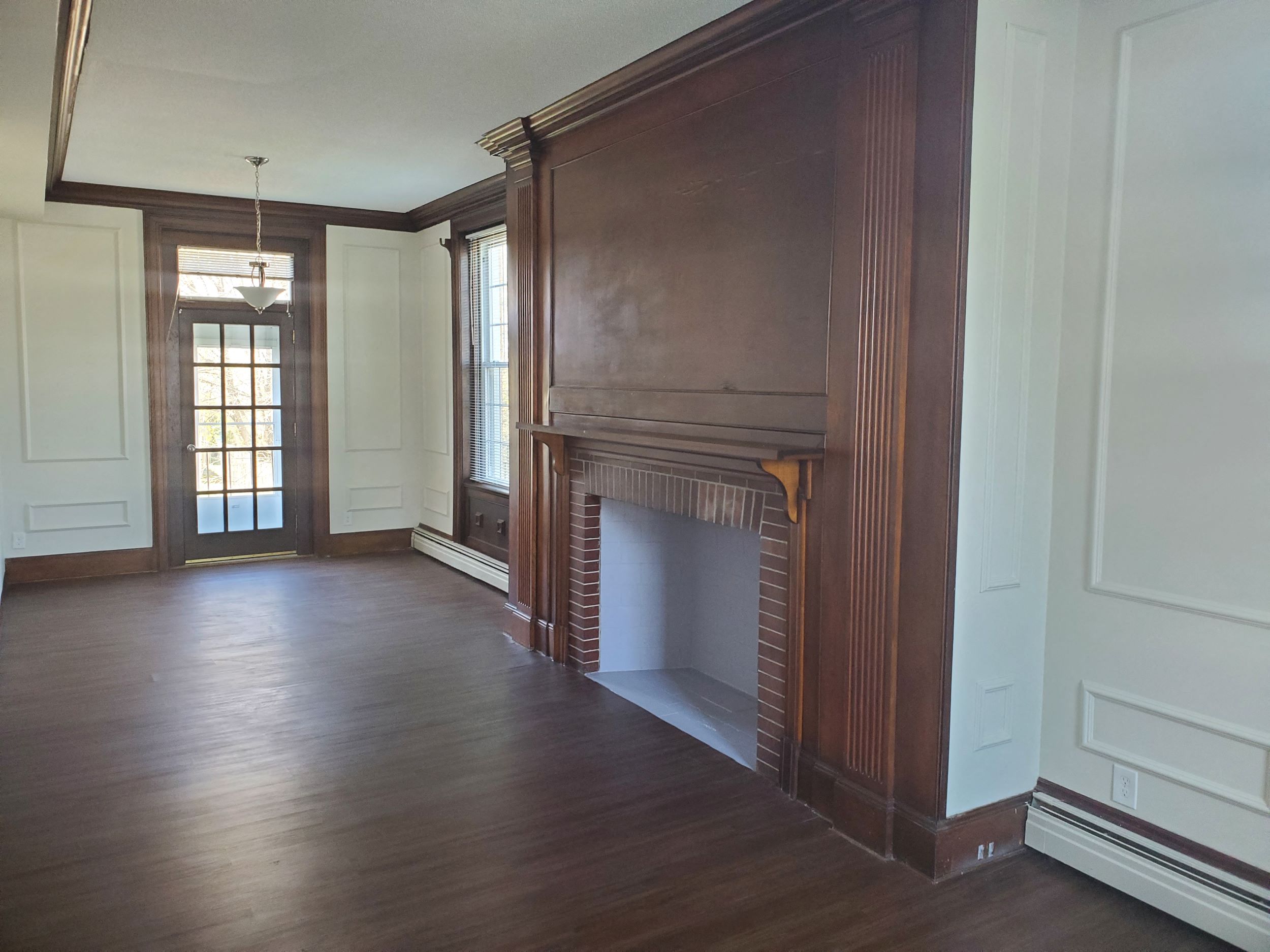 a living room with a fireplace and a wooden floor