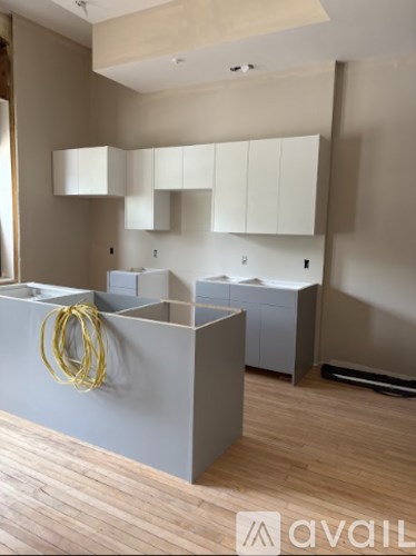 A spacious room with wooden floors and large windows.