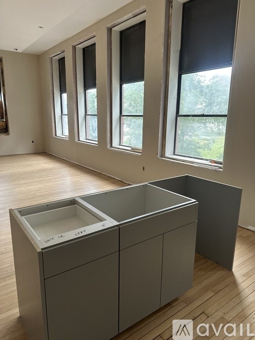 A kitchen with a large island and grey cabinets.