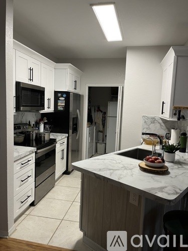 A kitchen with a marble countertop and a bowl of fruit on it.