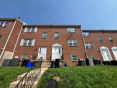 A red brick apartment building with a white door and windows.
