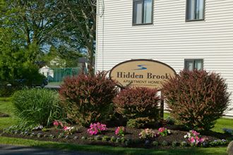 a sign apartments in front of a flower garden