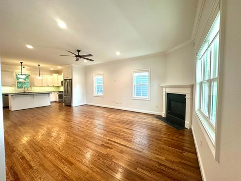 A spacious living room with hardwood floors and a fireplace.