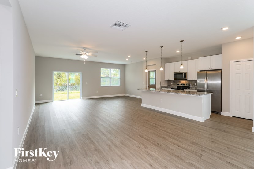 A spacious kitchen with a refrigerator, microwave, and oven.