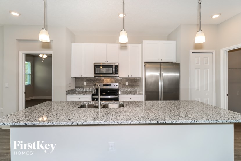 A kitchen with granite countertops and a FirstKey Homes logo.