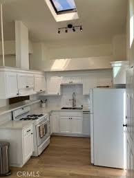 A kitchen with white appliances and cabinets.
