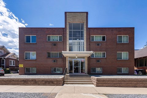 A red brick building with a white entrance and a glass window.
