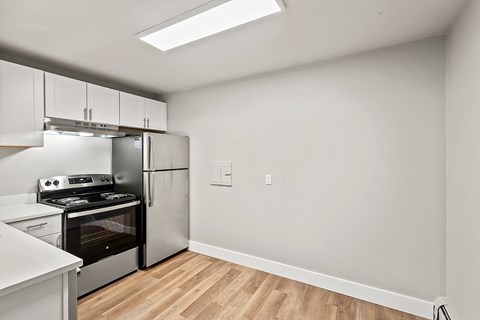 A kitchen with a stove top oven and a refrigerator.