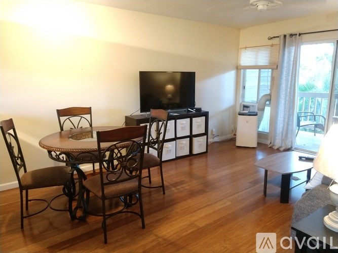 A living room with a TV, chairs, and a dining table.