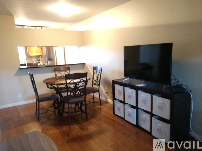 A living room with a television and a dining table.