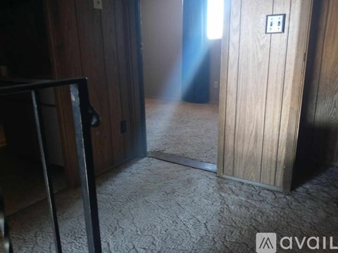 A room with a carpeted floor and a wooden door.
