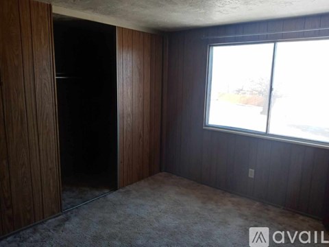 A room with a carpeted floor and a window showing daylight outside.