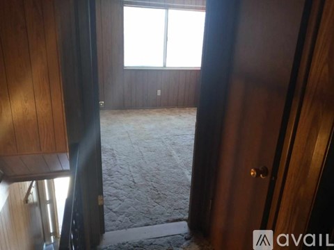 A room with a carpeted floor and a window.