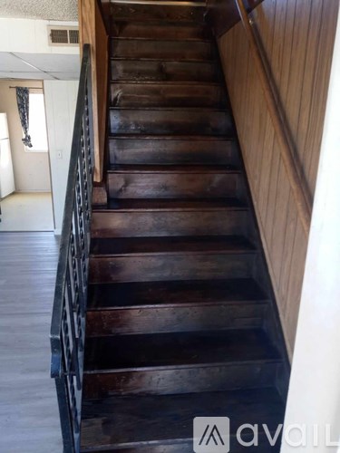 A staircase with a metal railing and wooden steps.