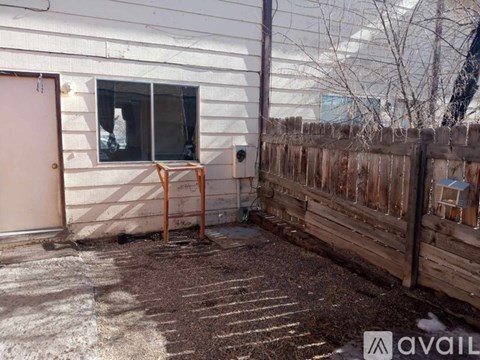 A backyard with a wooden fence and a small table and chair set.
