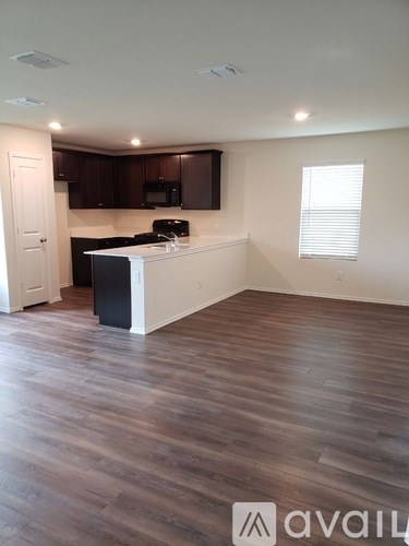 A kitchen with dark wood cabinets and a white island.