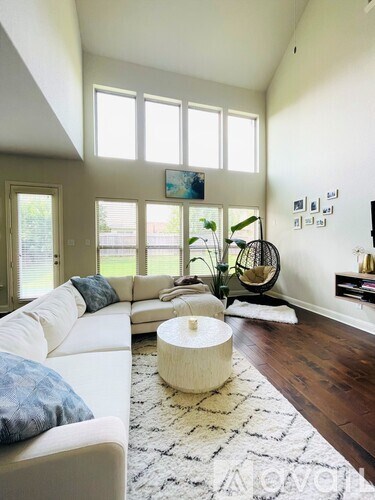 A living room with a white couch and a large window.