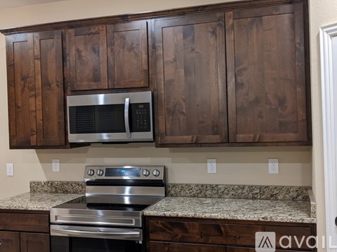 A kitchen with wooden cabinets and a stainless steel oven.