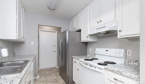 A kitchen with white cabinets and a granite countertop.