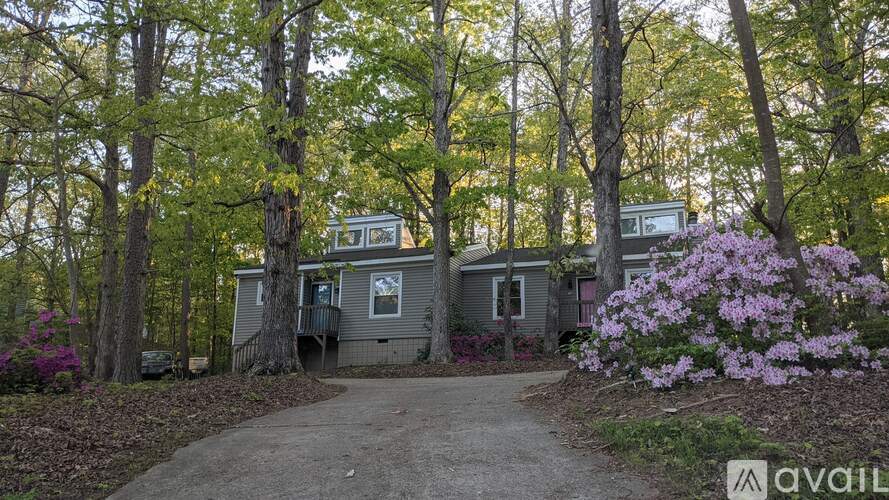 A house surrounded by trees with a sign that says "available".
