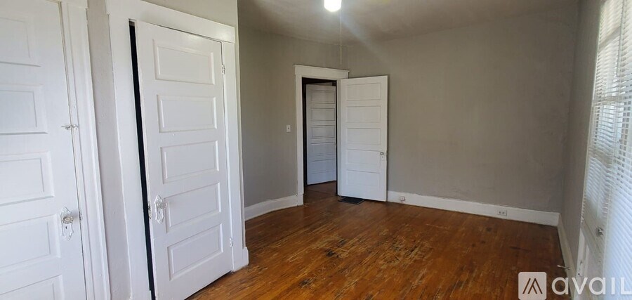 A room with wooden floors and white doors.