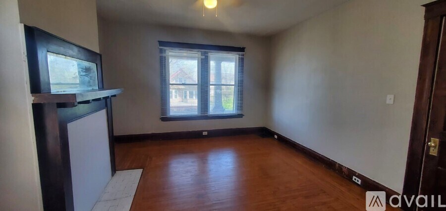 A room with wooden floors and a window with blinds.