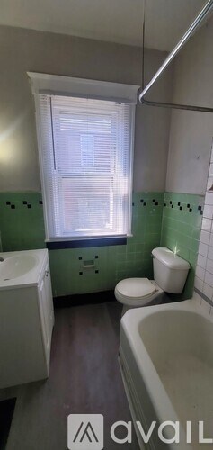 A bathroom with green walls and a white toilet.
