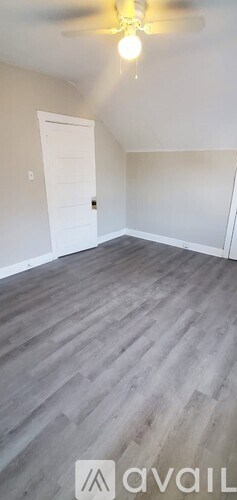A room with a white door and a ceiling fan.