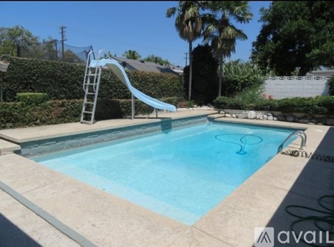 A small pool with a slide in the backyard.