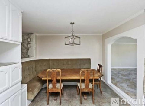A dining room with a table and chairs.
