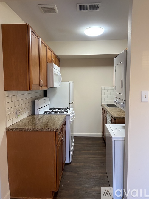 A kitchen with brown cabinets and a white refrigerator.