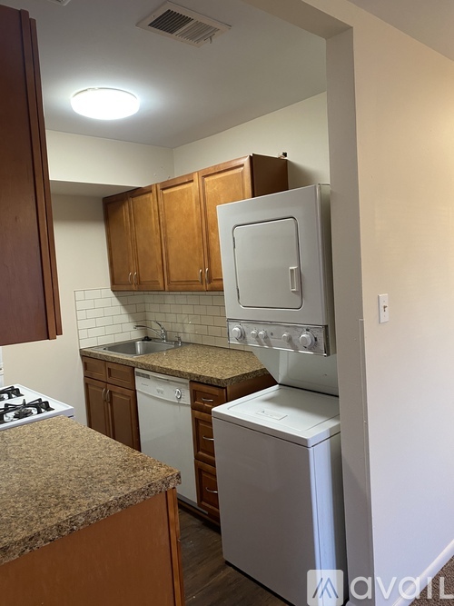 A kitchen with a white stove top oven and a white dishwasher.