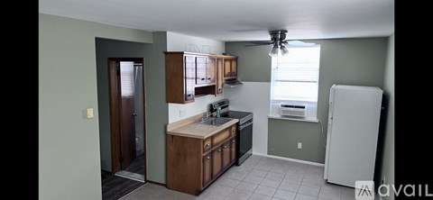 A kitchen with a white refrigerator and wooden cabinets.