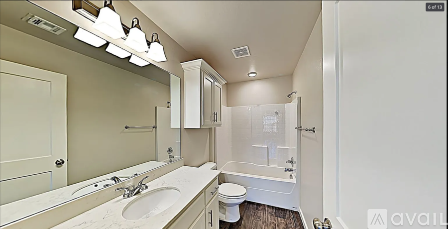 A bathroom with a toilet, sink, and mirror.