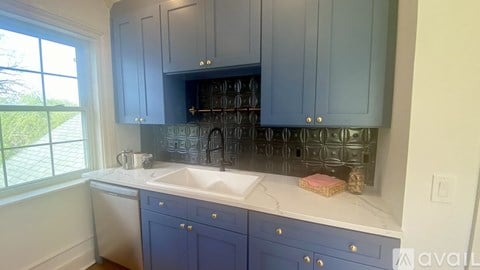 A kitchen with blue cabinets and a white countertop.