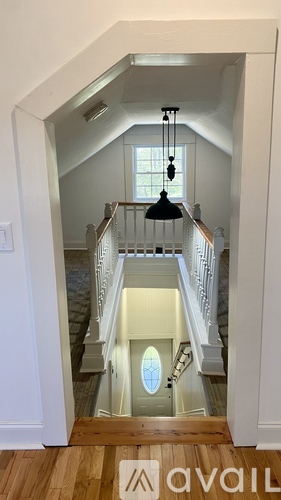 A staircase with a chandelier hanging above it.