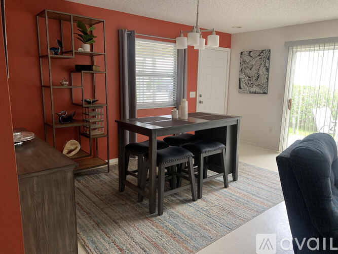 A dining room with a table and chairs.