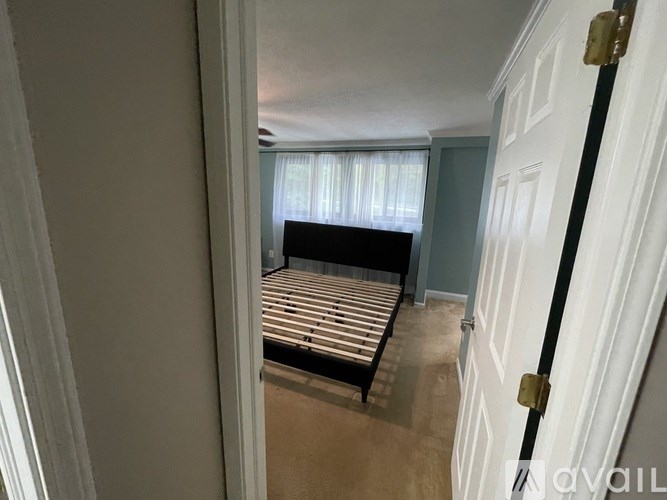 A bedroom with a bed and a window with curtains.