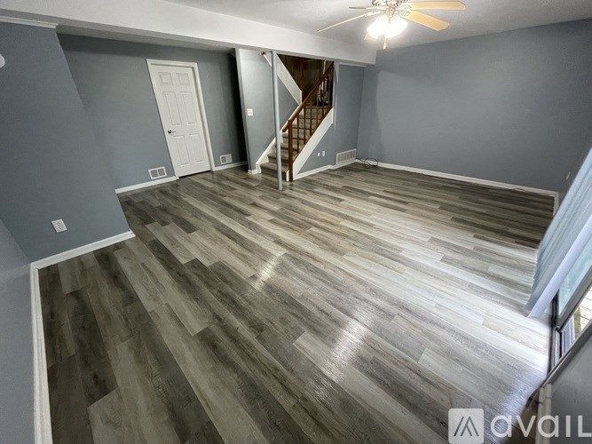 A spacious room with a staircase leading to the upper floor.
