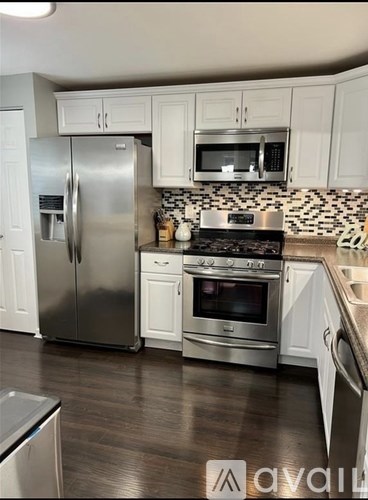 A kitchen with a stainless steel refrigerator, oven, and microwave.