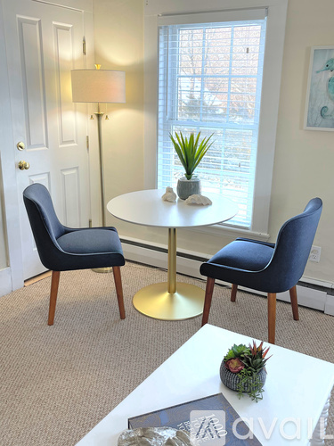 A white table with a gold base and a plant on it.