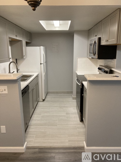 A kitchen with a white fridge and a black microwave.