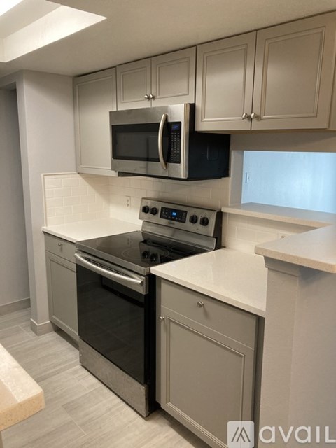 A kitchen with a black microwave above a stove.