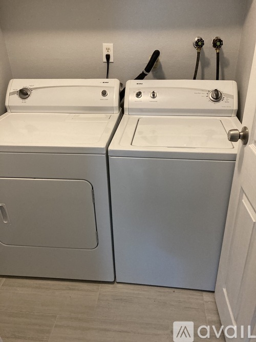A white washing machine and dryer in a bathroom.
